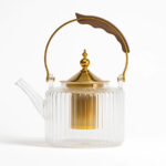 قوری-شیشه‌ای-و-طلایی-با-دسته-چوبی